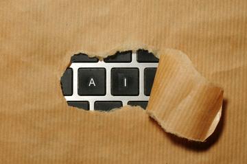 A piece of cardboard with a keyboard showing AI appearing