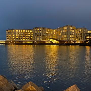 Evening photo of the WHO headquarters taken from across a body of water