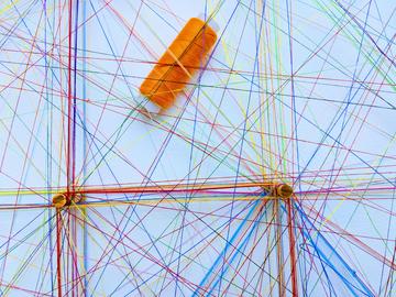 Assorted sewing threads of many different colours forming webs/networks. 