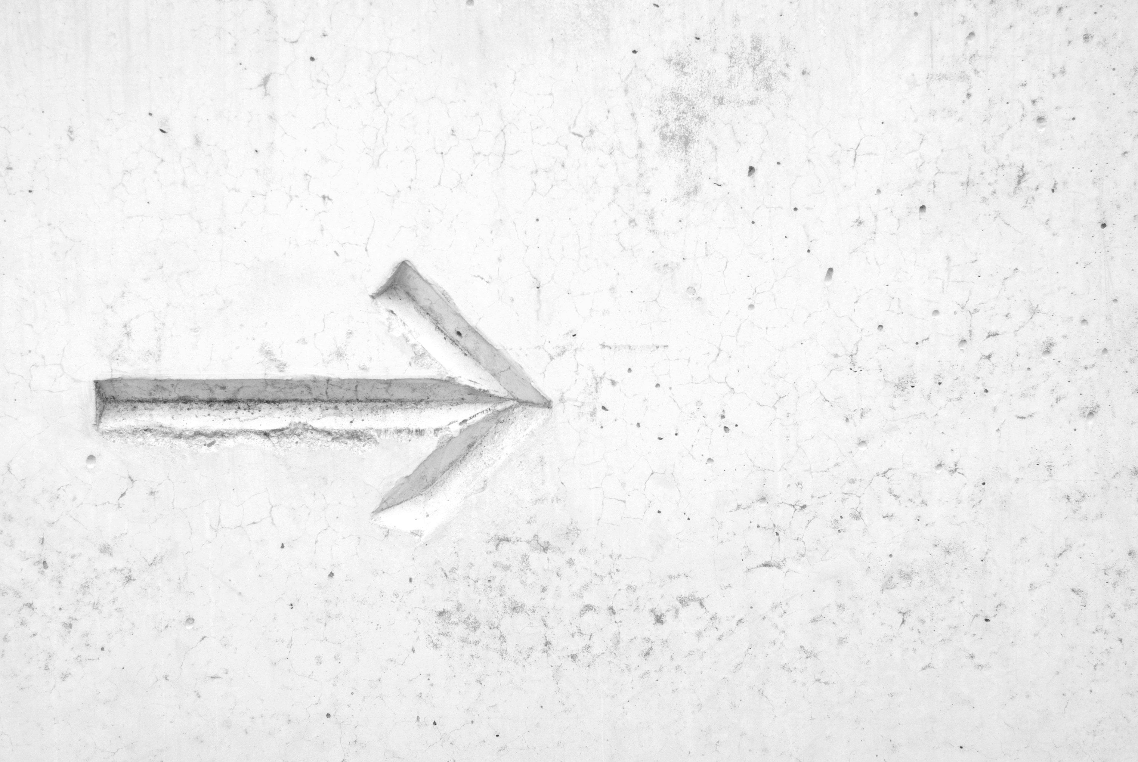 Arrow engraving on a white wall