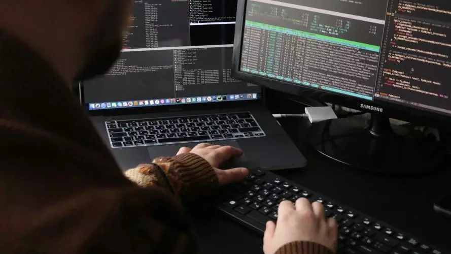 A man sitting in front of a computer on a desk