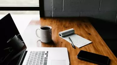 laptop on a table with a coffee