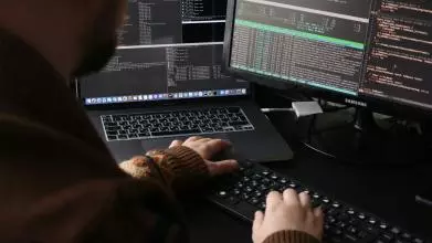 A man sitting in front of a computer on a desk