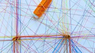 Assorted sewing threads of many different colours forming webs/networks. 